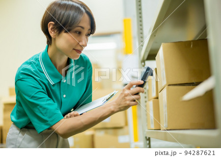 スキャンしながら在庫管理をする若い女性 94287621