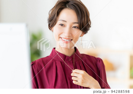 アクセサリーをつけるミドル女性 94288598