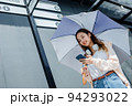 Beautiful Asian woman happiness holding umbrella and listening favourite music on headphones from mobile phone, Happiness relaxation summer in park with music 94293022