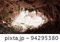 inside a limestone cave with plants and sun shine 94295380