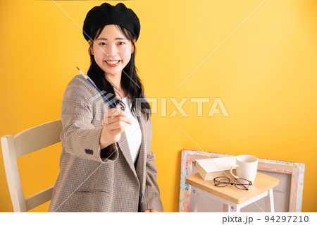 筆を持って笑顔の女性 94297210