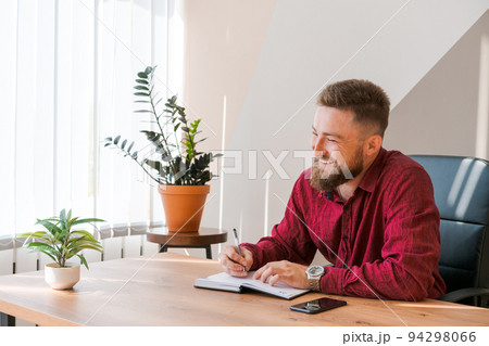 Portrait handsome smiling man with beard, working in office on some project, he 94298066
