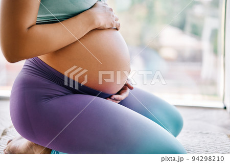 Closeup of pregnant woman holding her belly 94298210