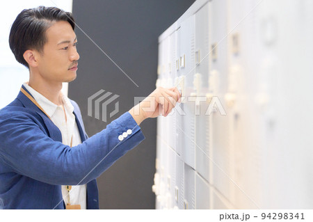 ロッカーの鍵を締めるビジネスパーソン 94298341