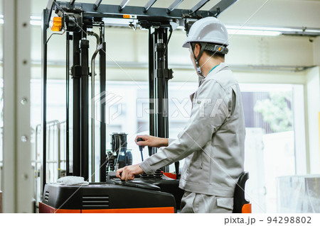 物流倉庫でフォークリフトを運転する有資格の男性社員 物流倉庫でフォークリフトを運転する有資格の男性社員 94298802