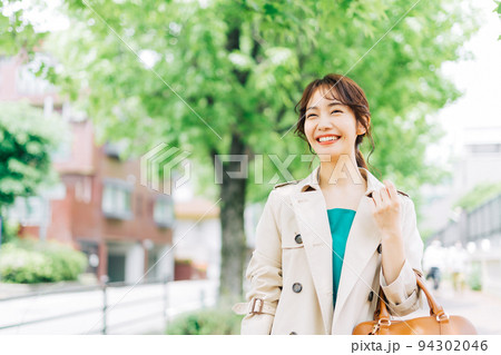 トレンチコートを着て出掛ける女性 94302046