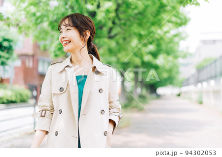 トレンチコートを着て出掛ける女性 94302053