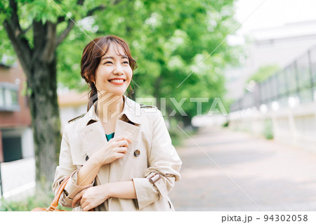 トレンチコートを着て出掛ける女性 94302058