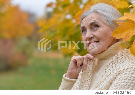 Senior woman walking in the park in autumn 94302460