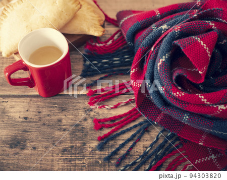 Cozy and warm red and black blanket, cup of hot coffee and freshly baked pies for a cold winter day 94303820