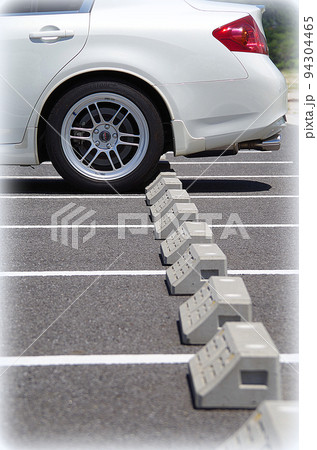バック駐車した乗用車の後輪が駐車場の車止めに当たった状態（イラスト風） 94304465