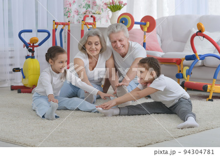 Grandfather and grandmother together with their granddaughters are training Grandfather and grandmother together with their granddaughters are training 94304781