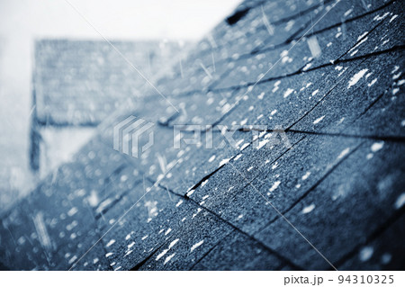 it is snowing above the shingle roof 94310325