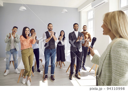 Happy diverse audience giving speaker standing ovation for good business lecture Happy diverse audience giving speaker standing ovation for good business lecture 94310998