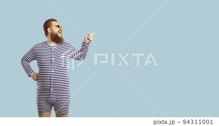 Funny fat guy in striped pajamas or swimsuit laughing and showing something on copy space Funny fat guy in striped pajamas or swimsuit laughing and showing something on copy space 94311001