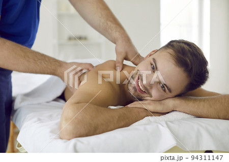 Smiling male client have massage in salon Smiling male client have massage in salon 94311147