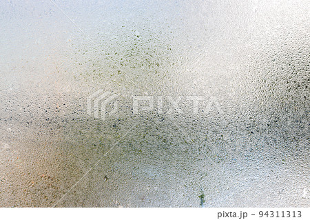 Misted glass, silver rain drops dew drops on transparent glass window Misted glass, silver rain drops dew drops on transparent glass window 94311313