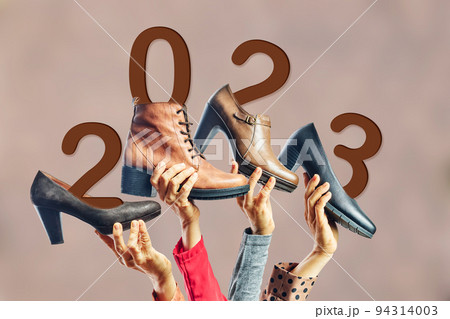 Hands holding different womens shoes and boots with year 2023 on them. New year concept Hands holding different womens shoes and boots with year 2023 on them. New year concept 94314003