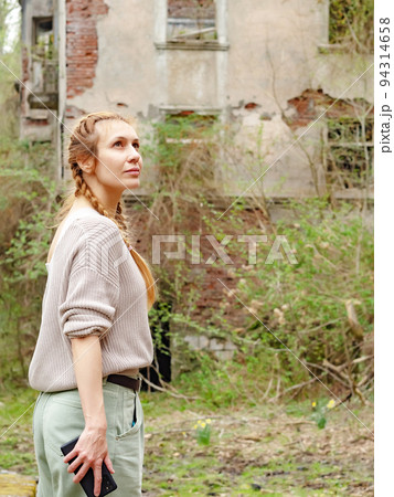 Woman looking at an overgrown abandoned city. Woman sightseeing in an abandoned city. Walk through the abandoned city. Woman looking at an overgrown abandoned city. Woman sightseeing in an abandoned city. Walk through the abandoned city. 94314658