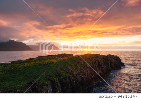Sunset over mountain cape with puffins colony in summer on Eastern at Borgarfjardarhofn, Iceland Sunset over mountain cape with puffins colony in summer on Eastern at Borgarfjardarhofn, Iceland 94315347