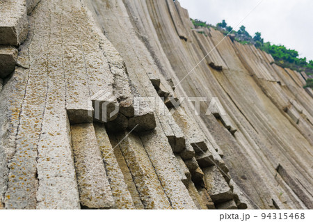 basalt columns forming a coastal rock at Cape Stolbchaty on Kunashir Island, close-up basalt columns forming a coastal rock at Cape Stolbchaty on Kunashir Island, close-up 94315468