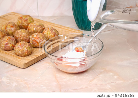 A man pours hot water into a sauce to cook lazy 94316868
