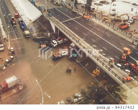construction of a new bridge in the city center, view from above. construction machinery is working on laying new asphalt. marking and pavement construction of a new bridge in the city center, view from above. construction machinery is working on laying new asphalt. marking and pavement 94317432