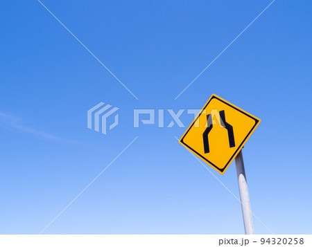 道路標識(警戒標識)「幅員減少」と青空。 94320258