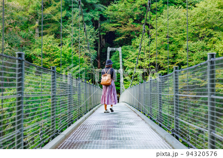 吊り橋を渡る女性・天龍峡の吊り橋(つつじ橋） 94320576