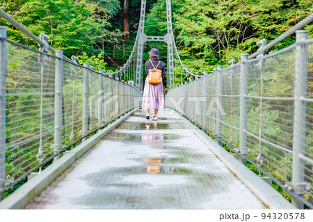 吊り橋を渡る女性・天龍峡の吊り橋(つつじ橋） 94320578