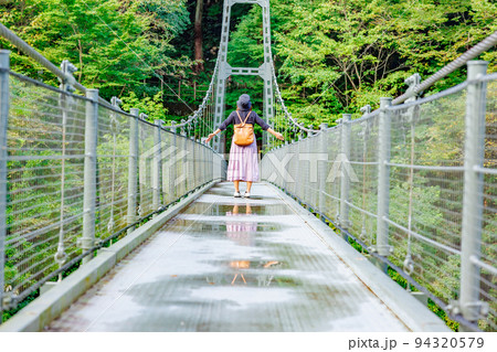 吊り橋を渡る女性・天龍峡の吊り橋(つつじ橋） 94320579