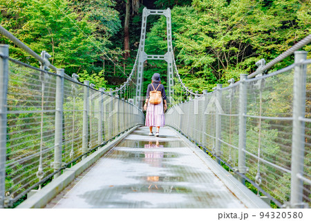 吊り橋を渡る女性・天龍峡の吊り橋(つつじ橋） 94320580