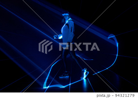 Woman is using virtual reality headset to access in metaverse. 94321279