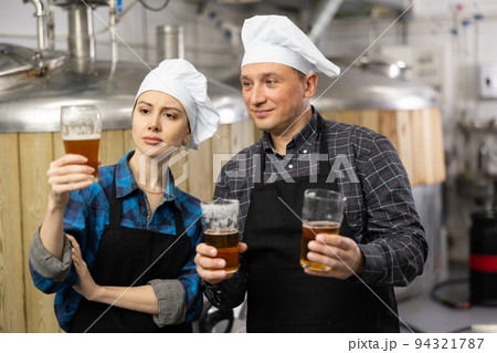 Man and woman - brewery owners with glasses of beer Man and woman - brewery owners with glasses of beer 94321787