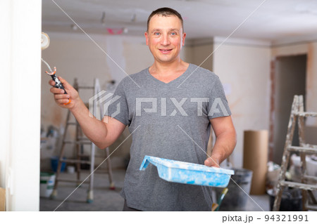 Man painting wall in apartment Man painting wall in apartment 94321991