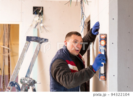 Builder checks the vertical of the wall using level 94322104