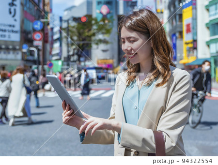 タブレットを操作する若い女性　渋谷スクランブル交差点　 94322554