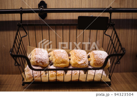 Chocolate buns sprinkled with icing sugar. 94323504