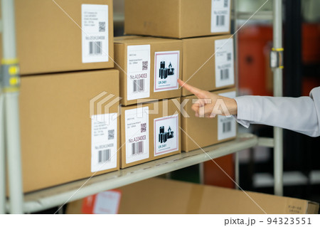 リチウムイオン電池の在庫状況を確認する女性スタッフ 94323551