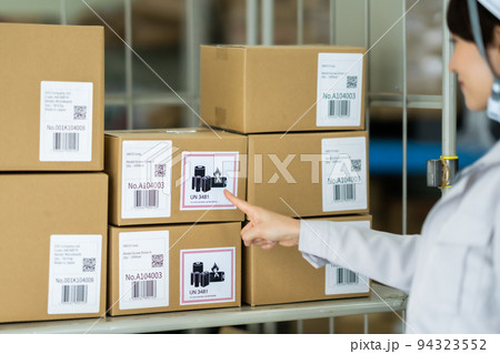 リチウムイオン電池の在庫状況を確認する女性スタッフ 94323552