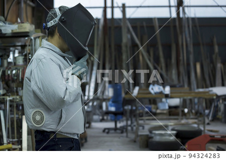 工場内で溶接マスクをする空調作業服を着た作業員男性　 94324283