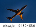 夕日を浴びて羽田空港離陸したジェット旅客機 94324630
