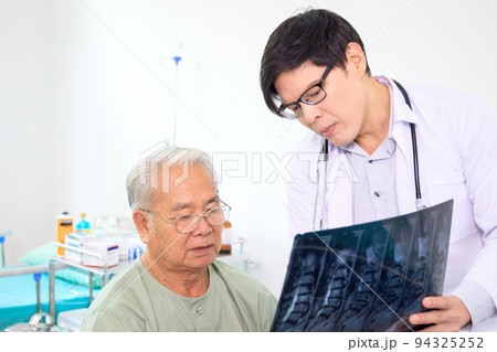 Asian elder adult having a consult with doctor about his disease, doctor explains the x-ray film to Asian senior adult. Health care and wellness in aging society. 94325252