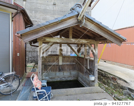 京丹後、伊根の舟屋地区の昔ながらの街並みの風景、共同井戸、瓦の乗った屋根と板囲いがある 京丹後、伊根の舟屋地区の昔ながらの街並みの風景、共同井戸、瓦の乗った屋根と板囲いがある 94327767