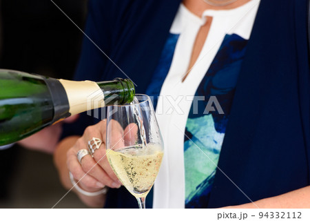 pooring champagne into a champagne flute 94332112