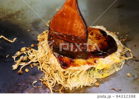 広島風お好み焼きにソースを塗る 広島風お好み焼きにソースを塗る 94332398