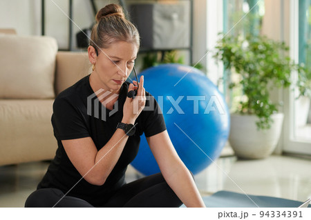 Fitness blogger checking new microphone before running class for her subscribers Fitness blogger checking new microphone before running class for her subscribers 94334391