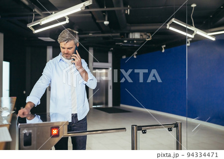 Portrait of a successful businessman with a beard, a man happily enters the office with a turnstile on a magnetic card 94334471