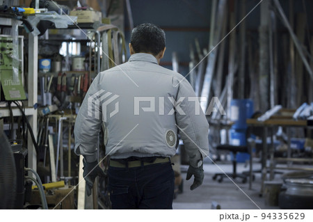 工場で空調作業服を着て働くミドル男性 工場で空調作業服を着て働くミドル男性 94335629