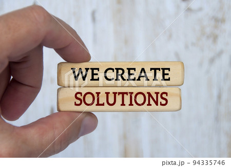 Hand holding wooden blocks with text - We create solutions. Problem solving concept. 94335746